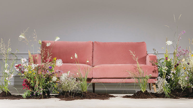 Kachel Nachhaltige Material auf soefa.com Rosa Sofa umgeben von Blumen, soefa.com